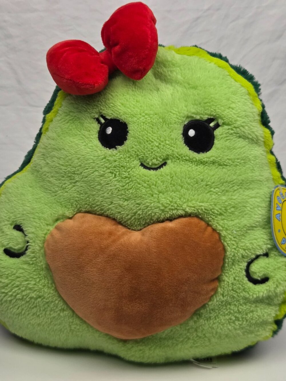 avocado plush pillow with a red bow and a brown heart-shaped 14"